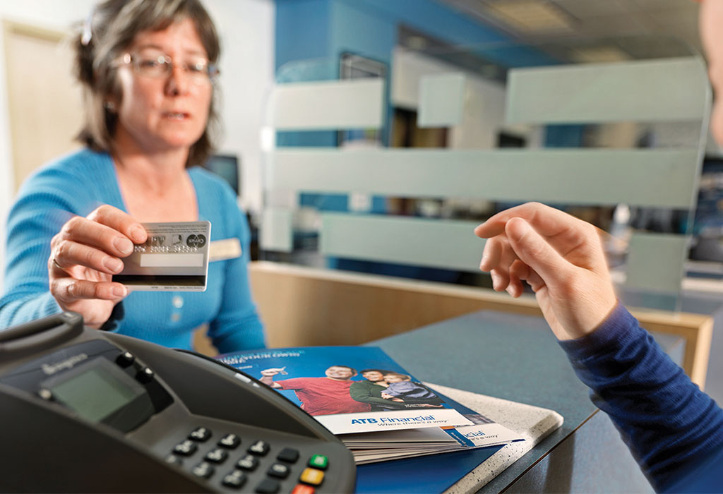 An ATB Financial employee assists a bank patron. 