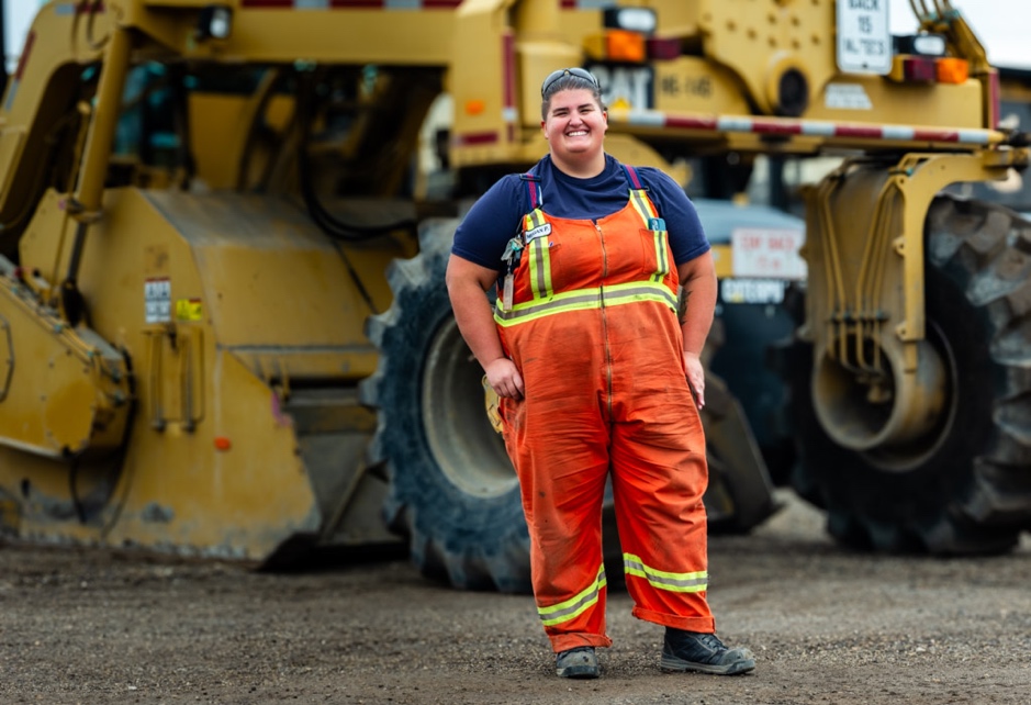 AUPE member standing in front of heavy machinery.